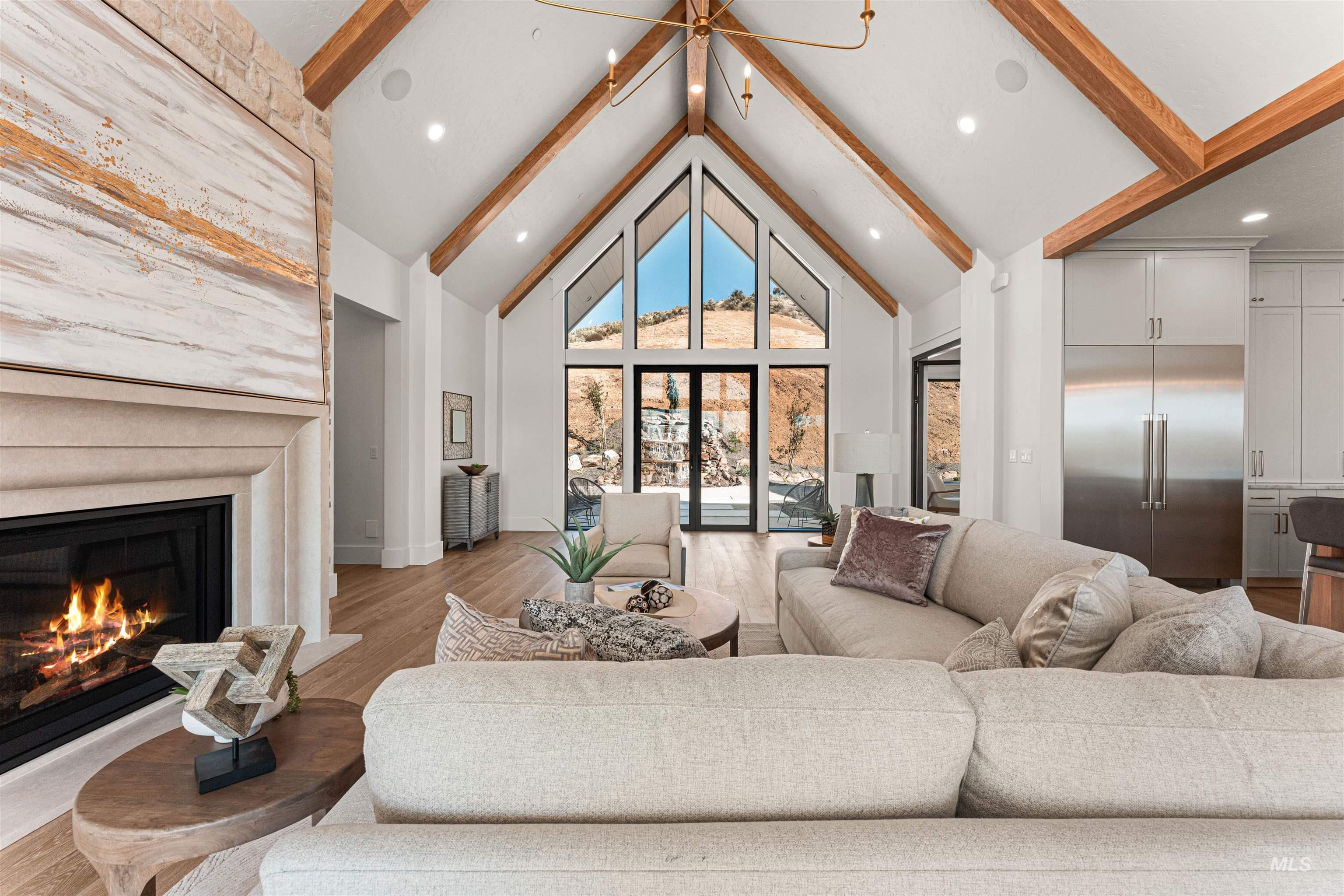 6400 North High Vly Way Eagle, ID 83714 - Photo 12 of 49 Living room featuring beam ceiling, high vaulted ceiling, wood finished floors, a glass covered fireplace, and recessed lighting