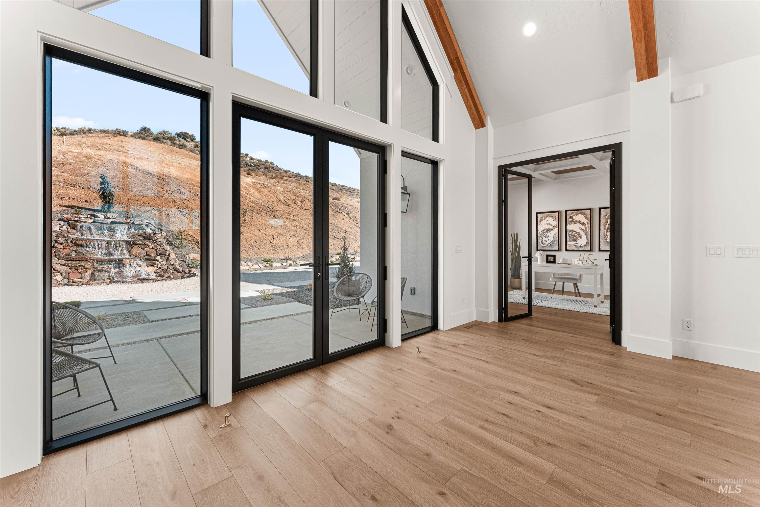 6400 North High Vly Way Eagle, ID 83714 - Photo 5 of 49 Doorway to outside with wood finished floors, high vaulted ceiling, and beam ceiling