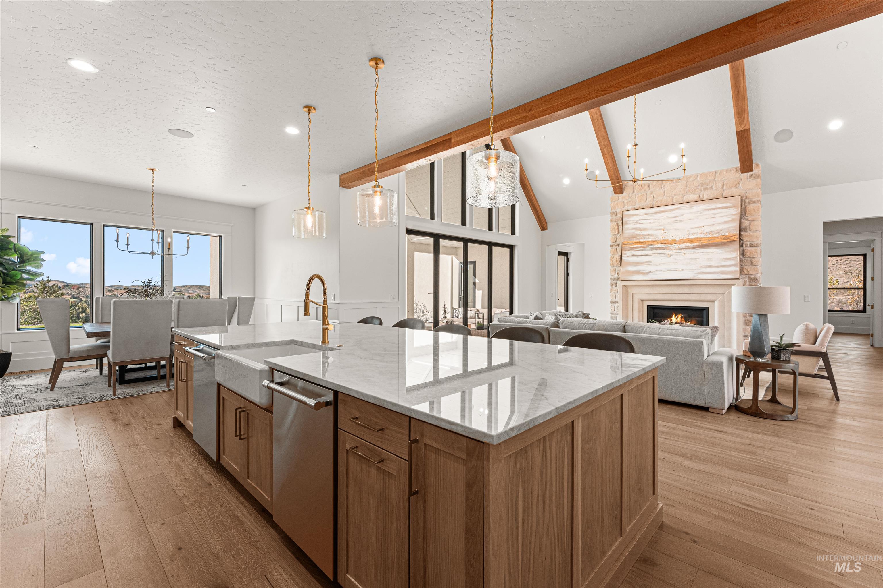 6400 North High Vly Way Eagle, ID 83714 - Photo 7 of 49 Kitchen with a chandelier, a fireplace, beam ceiling, light stone countertops, and decorative light fixtures