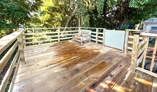 a view of a patio with table and chairs with wooden floor and fence
