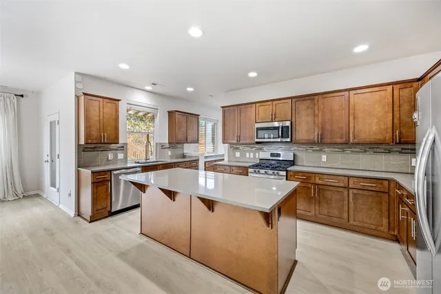 a kitchen with granite countertop a stove top oven sink and cabinets