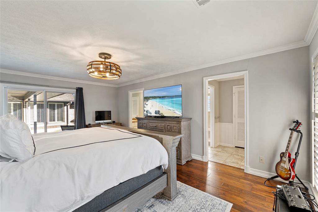 7116 Hunters Ridge Drive Dallas, TX 75248 - Photo 14 of 33 a bedroom with a bed and a chandelier