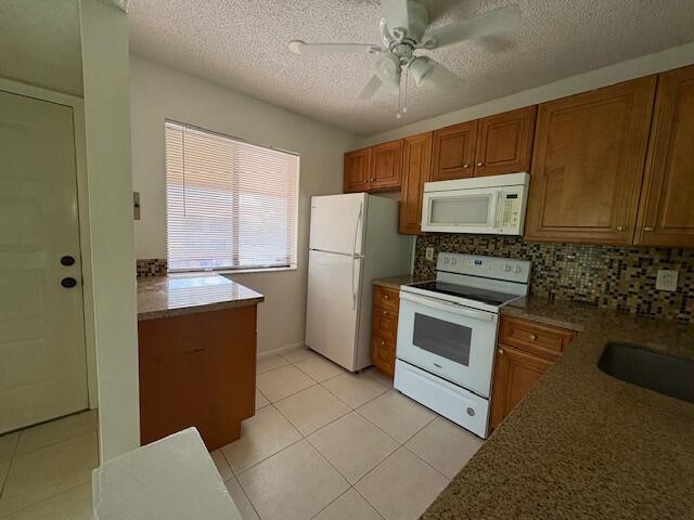 21938 Remsen Terrace, Unit 209 Boca Raton, FL 33433 - Photo 3 of 22 a kitchen with stainless steel appliances granite countertop a refrigerator a stove and a sink