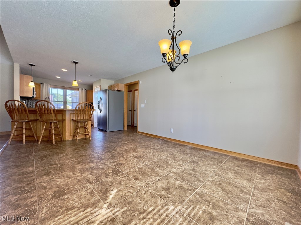 6014 Wentworth Road Southwest Canton, OH 44706 - Photo 5 of 22 Unfurnished dining area featuring tile flooring and a chandelier