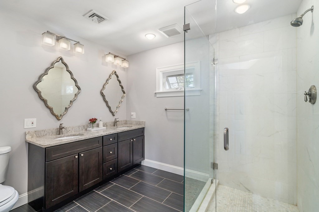 105 Brewster Road Waltham, MA 02451 - Photo 13 of 32 a bathroom with a double vanity sink mirror and shower