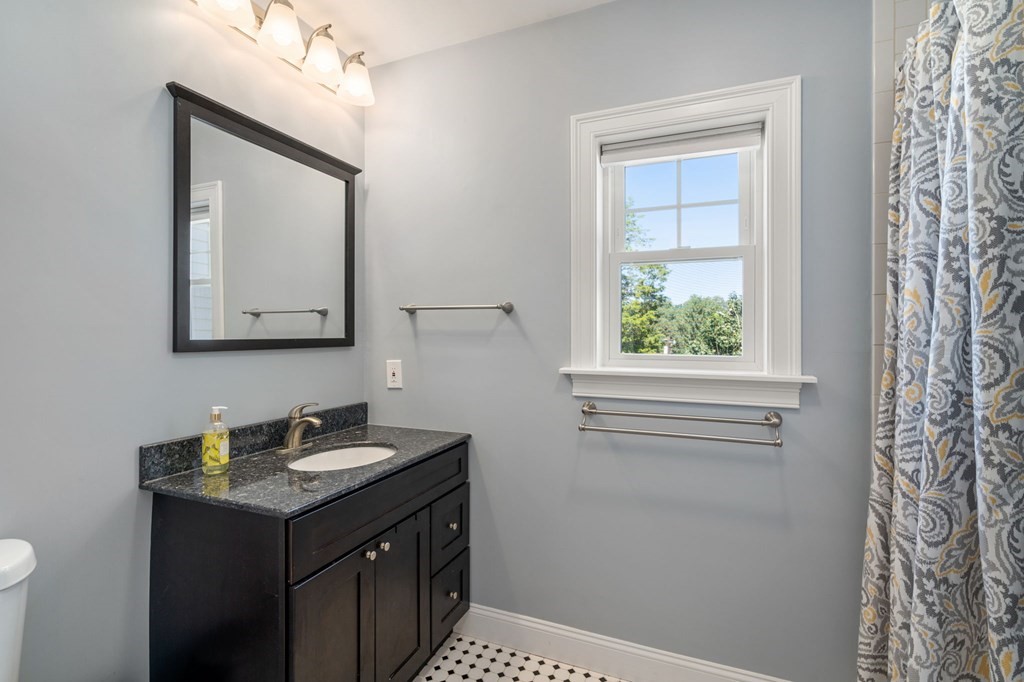 105 Brewster Road Waltham, MA 02451 - Photo 18 of 32 a bathroom with a sink a vanity and a mirror