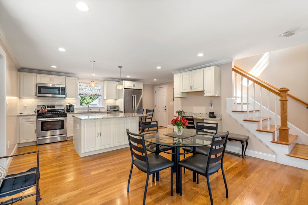 105 Brewster Road Waltham, MA 02451 - Photo 5 of 32 a kitchen with a dining table chairs and white cabinets
