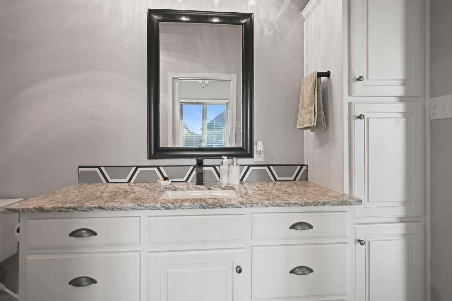 3416 141st Street Lubbock, TX 79423 - Photo 18 of 32 a bathroom with a granite countertop sink and mirror