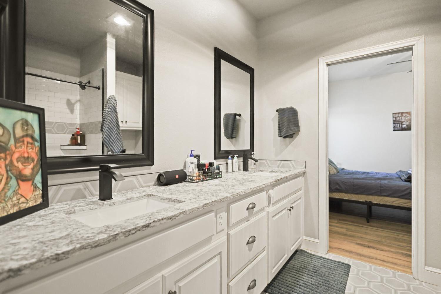 3416 141st Street Lubbock, TX 79423 - Photo 23 of 32 a bathroom with double vanity sinks and a mirror