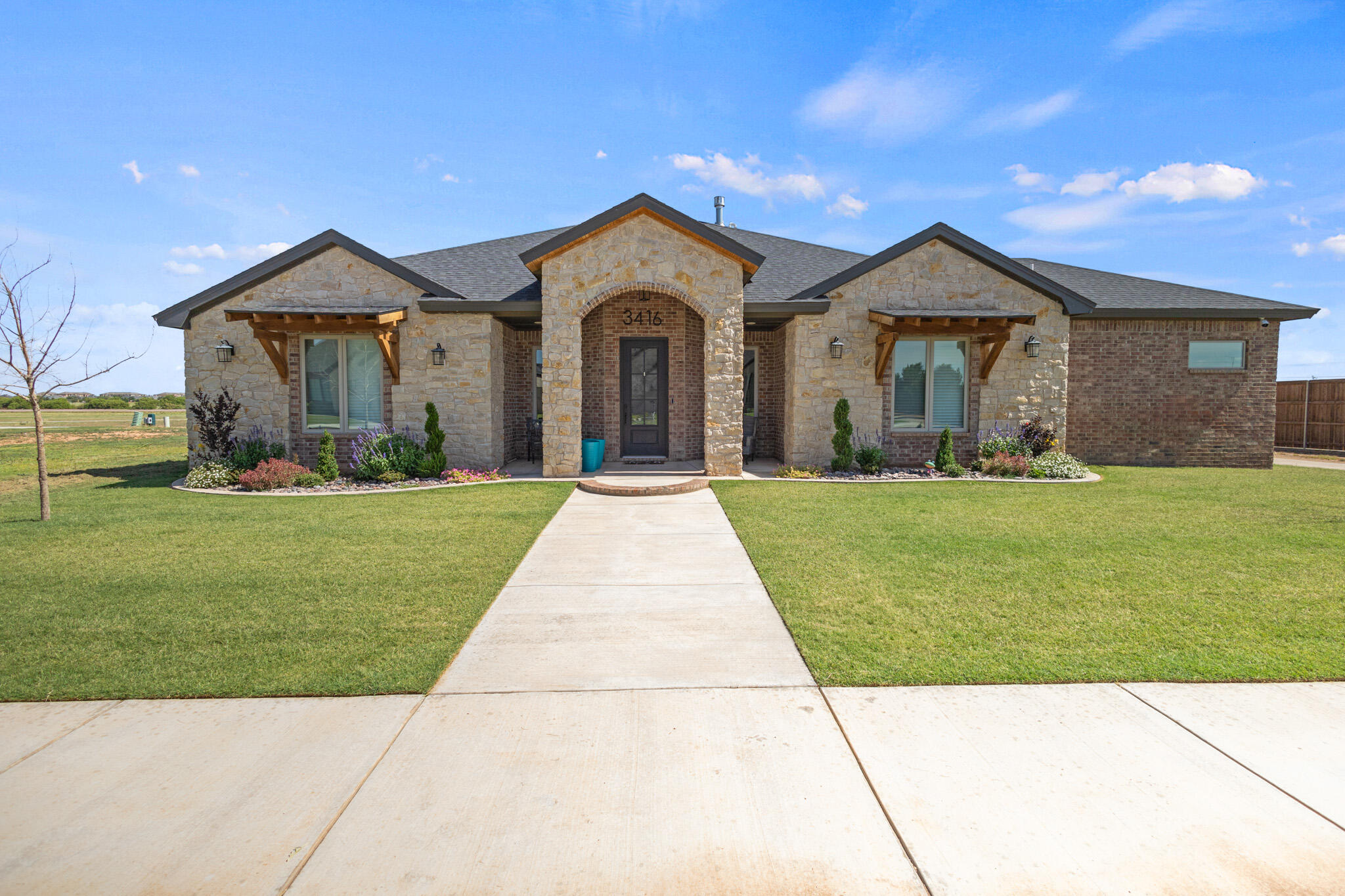 3416 141st Street Lubbock, TX 79423 - Photo 31 of 32 a front view of a house with a yard and potted plants