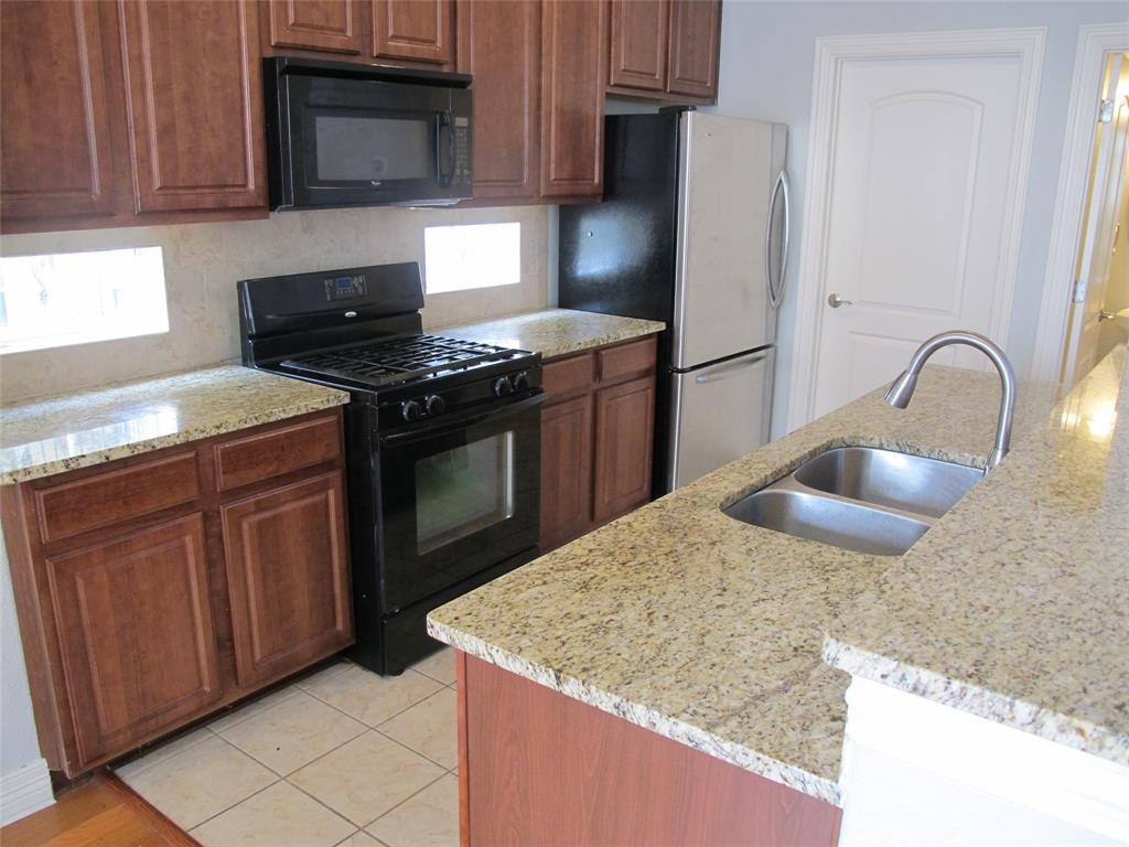 6715 Windrift Way, Unit 15 Austin, TX 78745 - Photo 11 of 37 a kitchen with granite countertop a stove and a sink