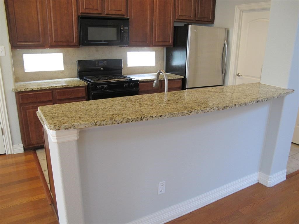 6715 Windrift Way, Unit 15 Austin, TX 78745 - Photo 13 of 37 a kitchen with stainless steel appliances granite countertop a stove a microwave a sink and cabinets