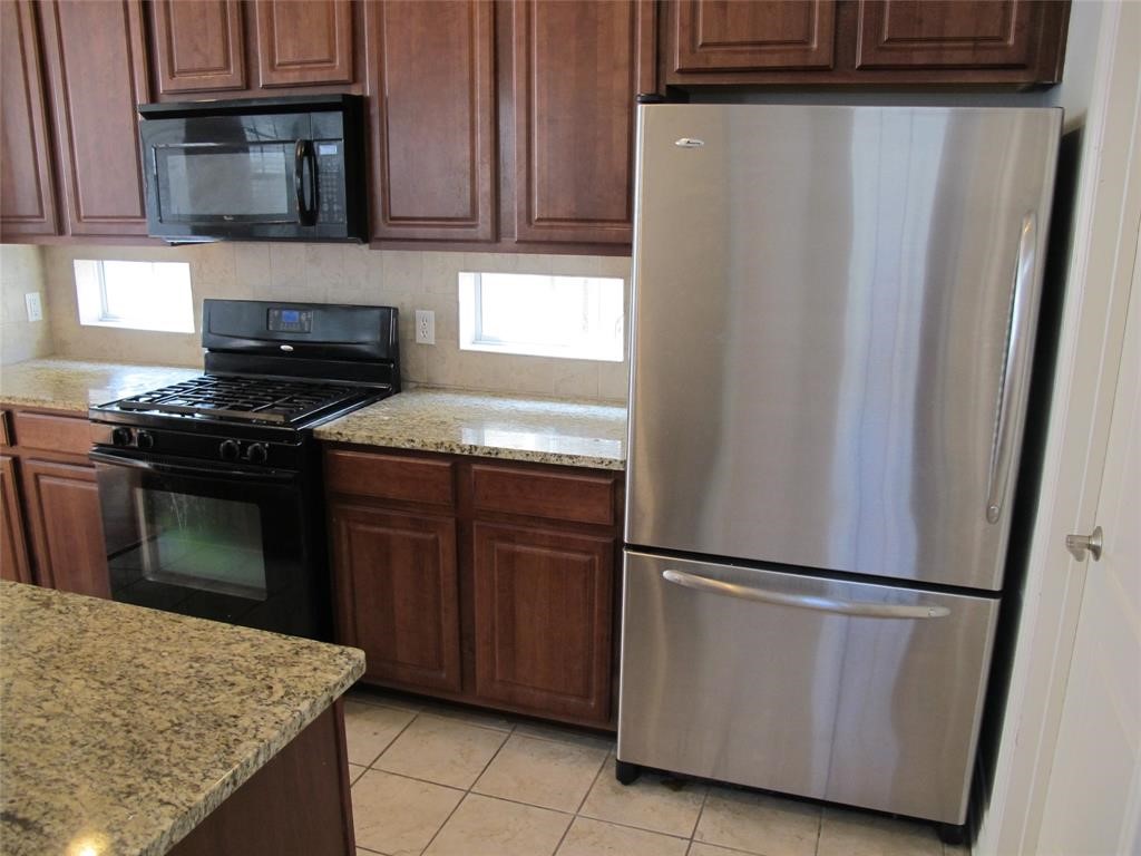 6715 Windrift Way, Unit 15 Austin, TX 78745 - Photo 14 of 37 a kitchen with stainless steel appliances granite countertop a refrigerator stove a sink and dishwasher