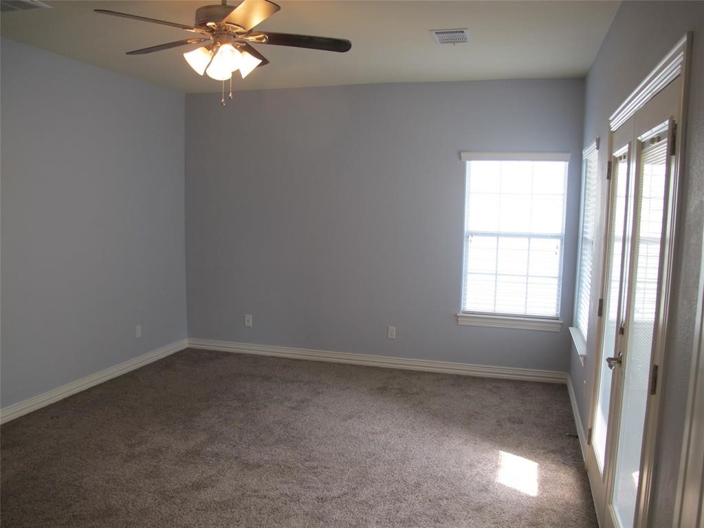 6715 Windrift Way, Unit 15 Austin, TX 78745 - Photo 25 of 37 en empty room with windows and chandelier fan