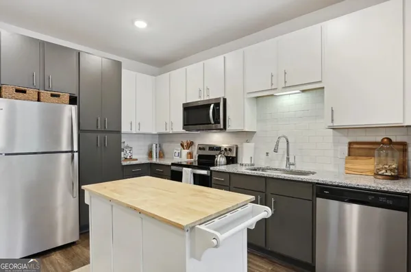 a kitchen with appliances a sink and cabinets