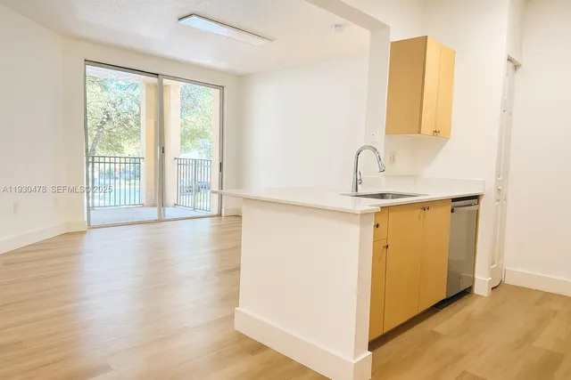 a view of a kitchen with wooden floor and a window