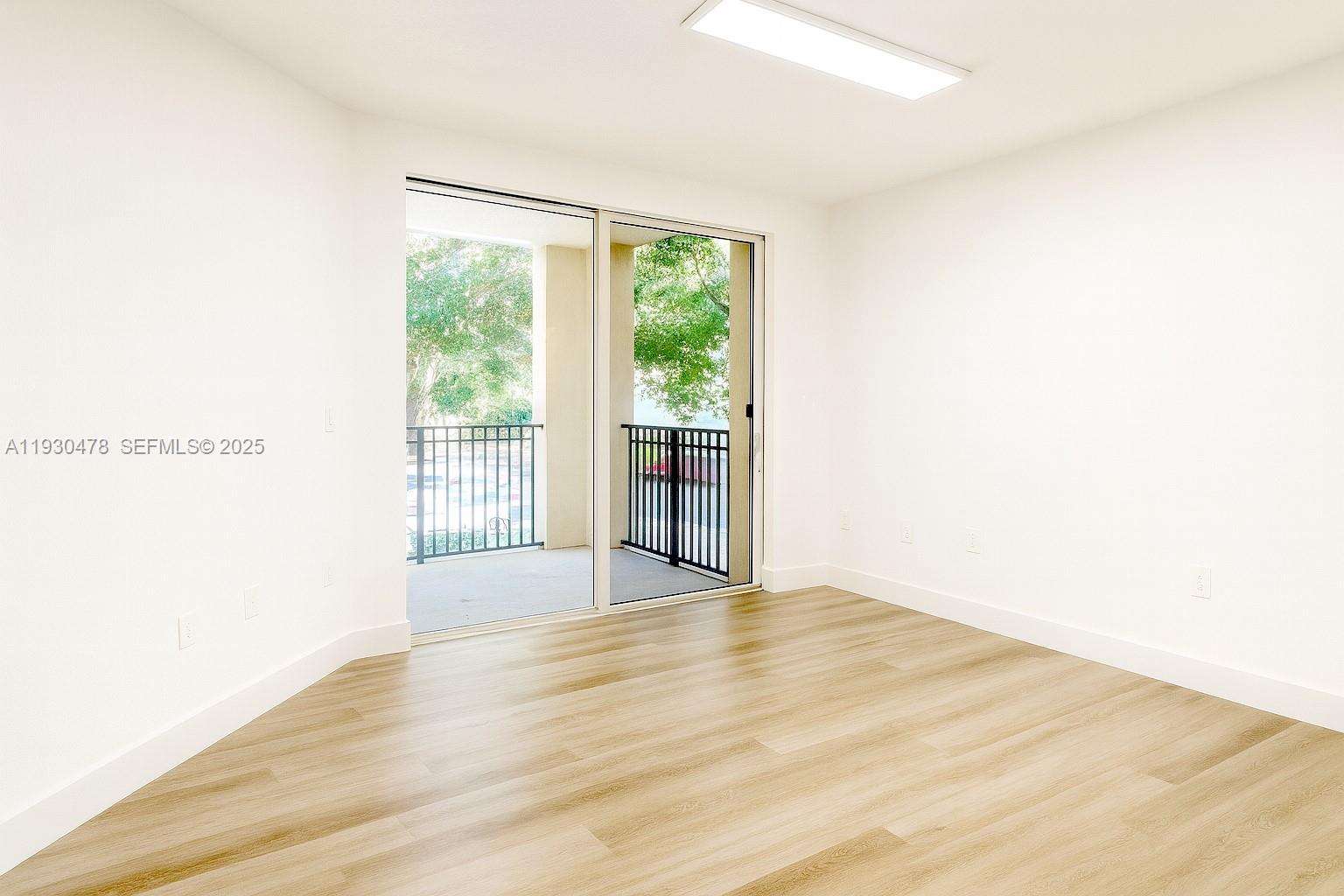 2564 Centergate Drive, Unit 208 Miramar, FL 33025 - Photo 12 of 31 a view of an empty room with wooden floor and a window