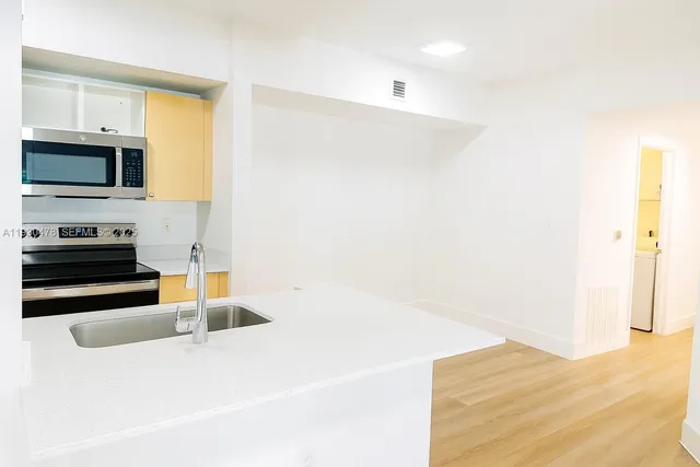 a kitchen with granite countertop a sink and a stove top oven
