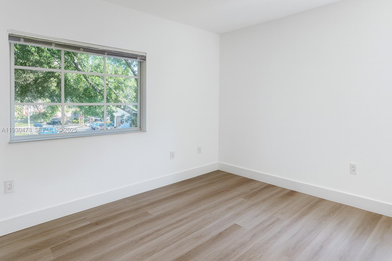 2564 Centergate Drive, Unit 208 Miramar, FL 33025 - Photo 19 of 31 a view of empty room with wooden floor and fan