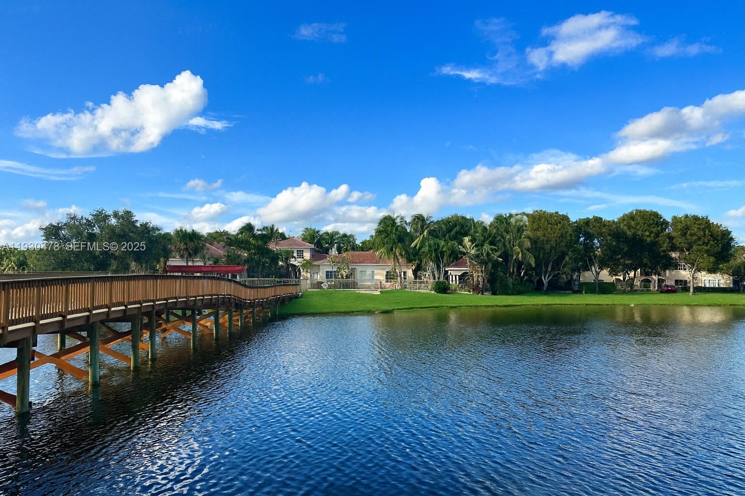 2564 Centergate Drive, Unit 208 Miramar, FL 33025 - Photo 27 of 31 a view of a lake with a house in the background