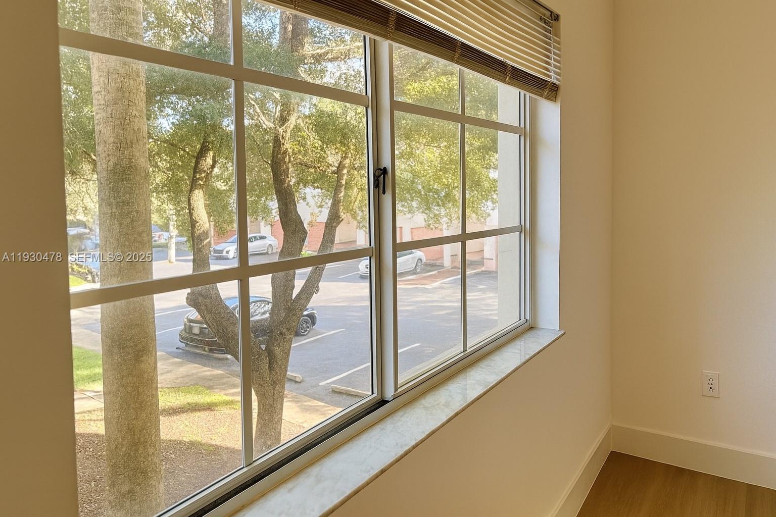 2564 Centergate Drive, Unit 208 Miramar, FL 33025 - Photo 4 of 31 a view of empty room with wooden floor and windows
