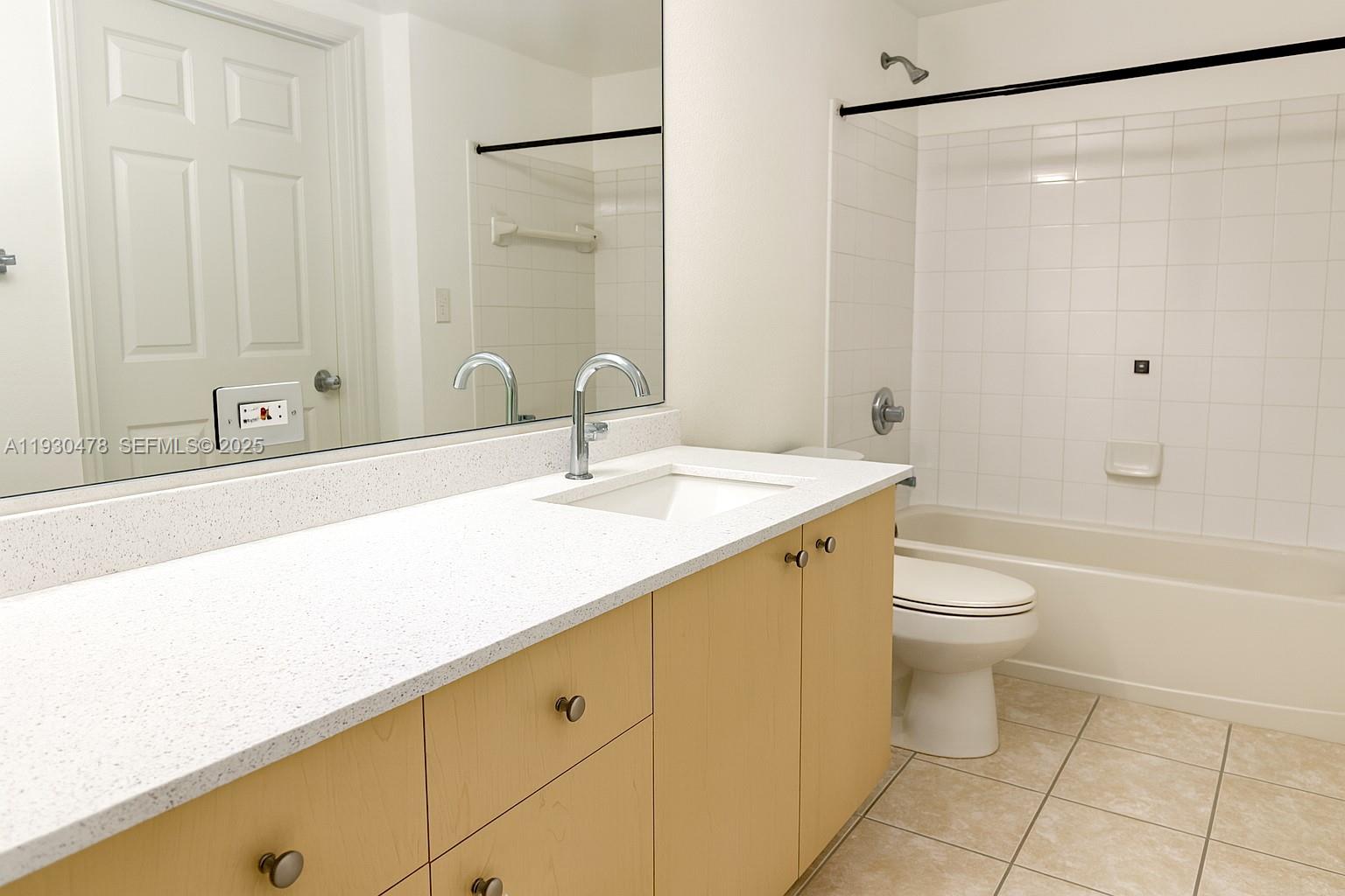 2564 Centergate Drive, Unit 208 Miramar, FL 33025 - Photo 8 of 31 a bathroom with a granite countertop sink a toilet and shower