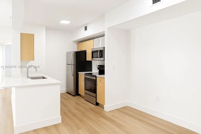 a kitchen with a sink cabinets and stainless steel appliances