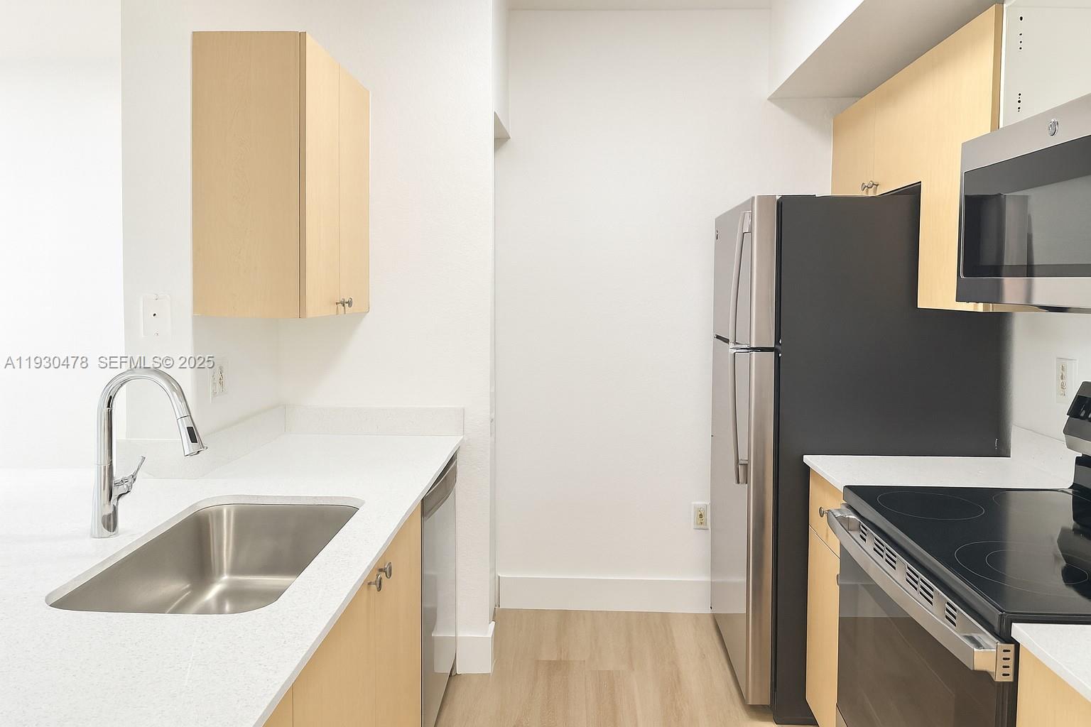 2564 Centergate Drive, Unit 208 Miramar, FL 33025 - Photo 10 of 31 a kitchen with a refrigerator sink and cabinets