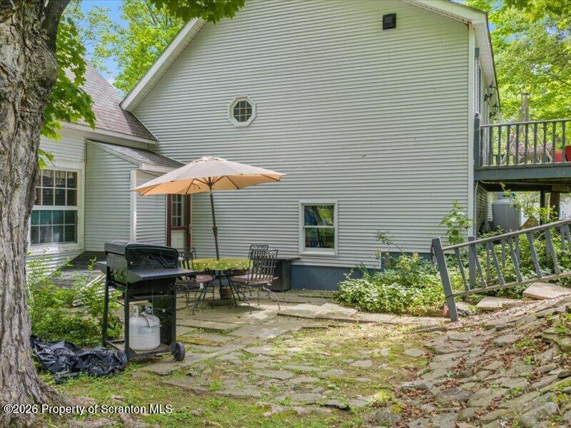 71 Pleasant Avenue Thompson, PA 18465 - Photo 32 of 37 a backyard of a house with barbeque oven table and chairs