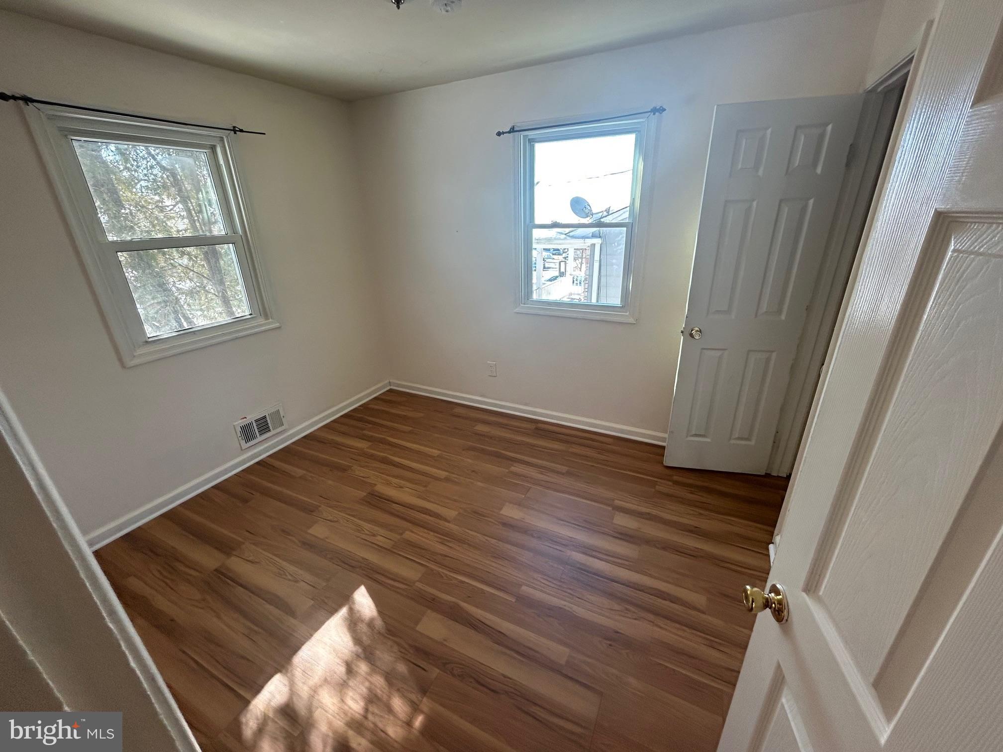 7208 Powhatan Street Lanham, MD 20706 - Photo 11 of 28 a view of an empty room with wooden floor and a window