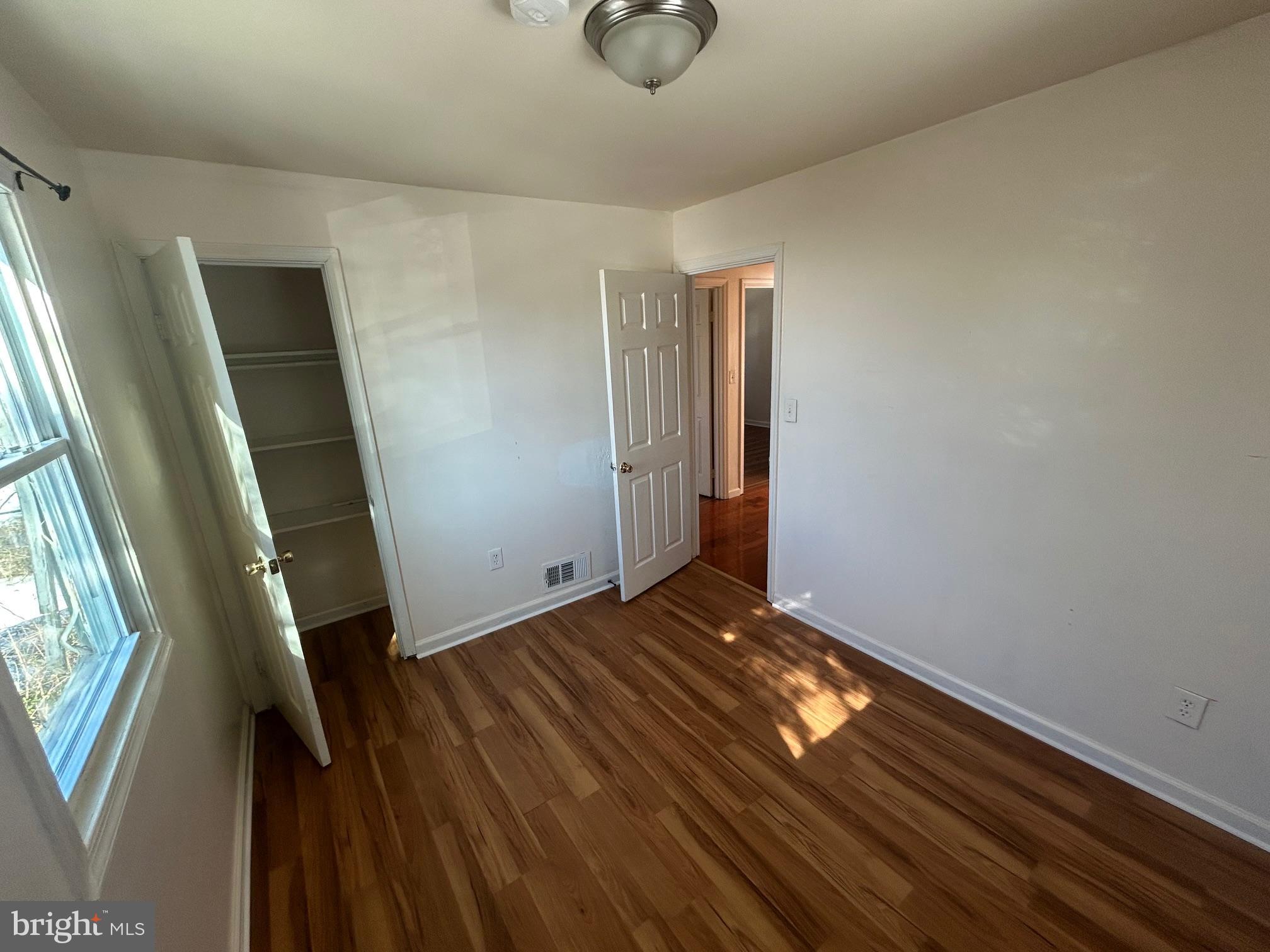 7208 Powhatan Street Lanham, MD 20706 - Photo 12 of 28 a view of an empty room with wooden floor and windows
