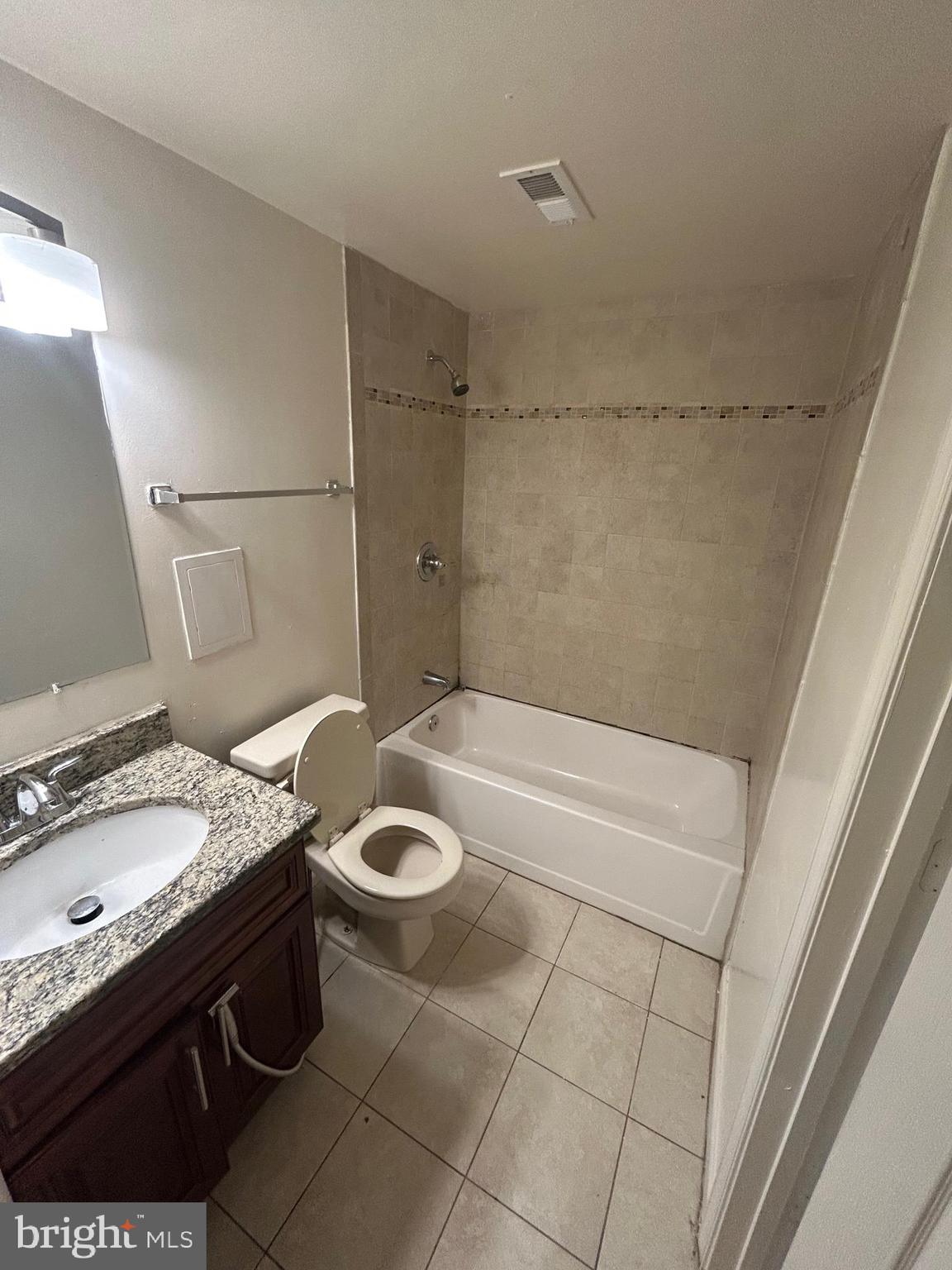 7208 Powhatan Street Lanham, MD 20706 - Photo 19 of 28 a bathroom with a granite countertop sink a toilet and bathtub