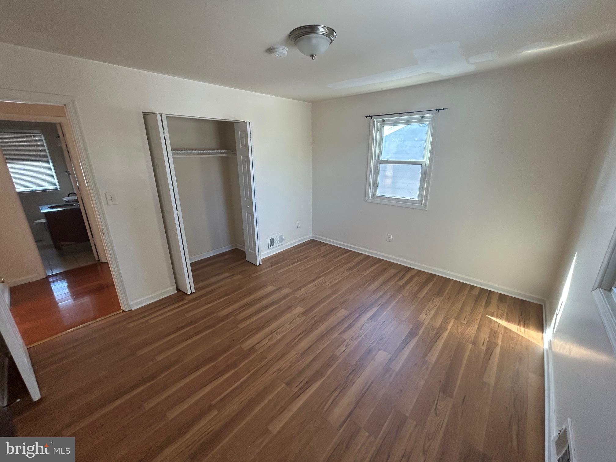 7208 Powhatan Street Lanham, MD 20706 - Photo 10 of 28 a view of an empty room with wooden floor and a window