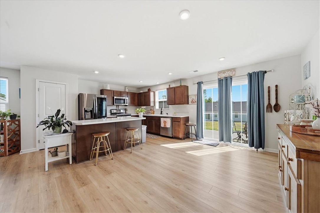 117 Alice Court Easley, SC 29642 - Photo 6 of 26 A grand kitchen island provides ample counter space, seamlessly connecting to an open living area with outdoor access.