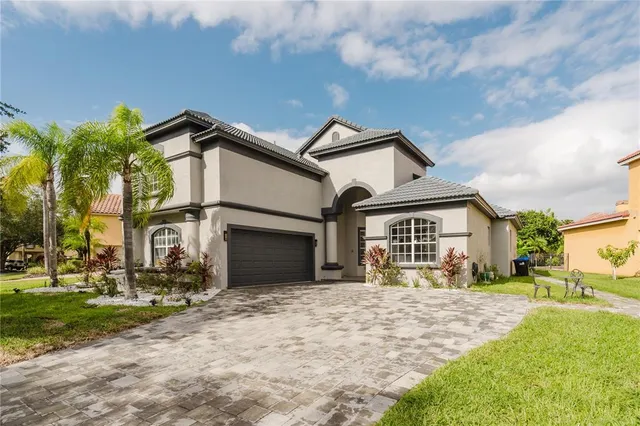 a front view of a house with a garden and trees