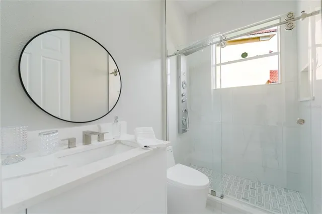 a bathroom with a sink mirror toilet and shower
