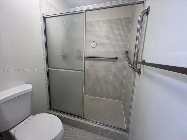a bathroom with a toilet and a shower