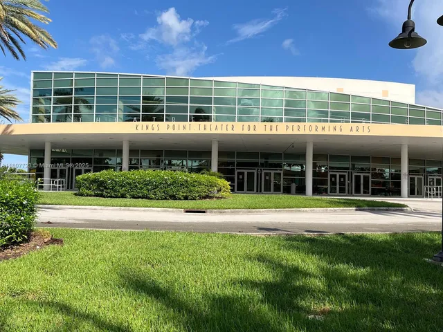 a view of an apartment with a house and a yard
