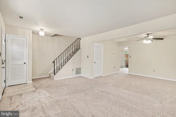 a view of an empty room with a chandelier fan