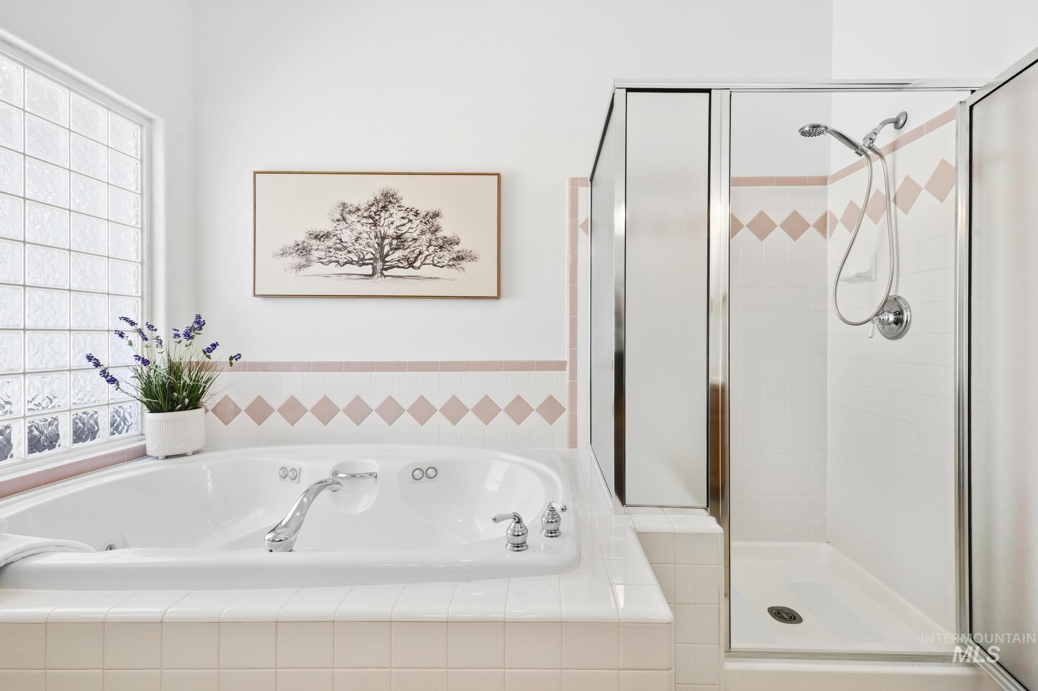 15181 Drury Way Caldwell, ID 83607 - Photo 24 of 49 Soaking tub featuring chrome fixtures and a glass block window
