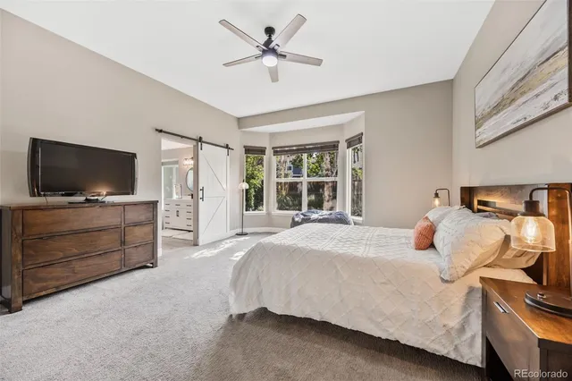 a bedroom with bed couch and window