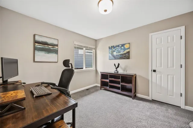 a view of a workspace with furniture and a window