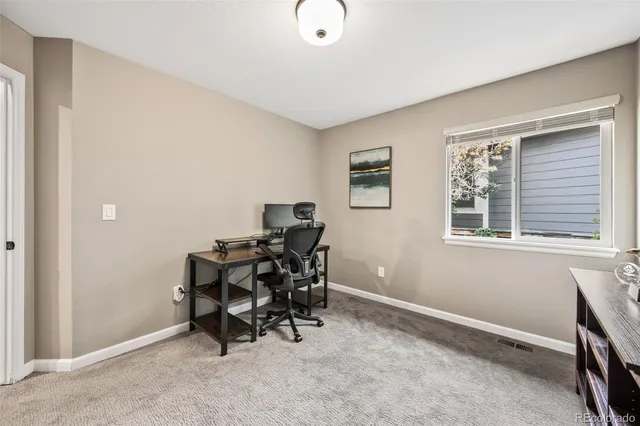 a view of a workspace with furniture and a window