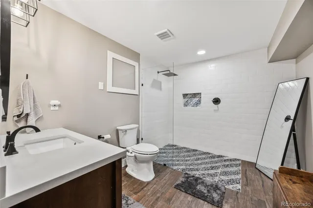 a bathroom with a toilet a sink and a mirror