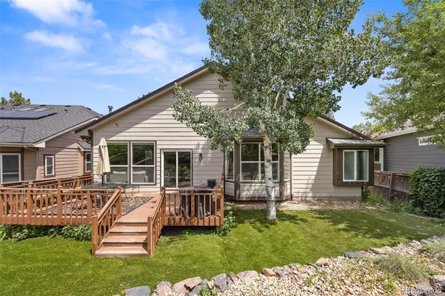 a view of a house with a yard and deck