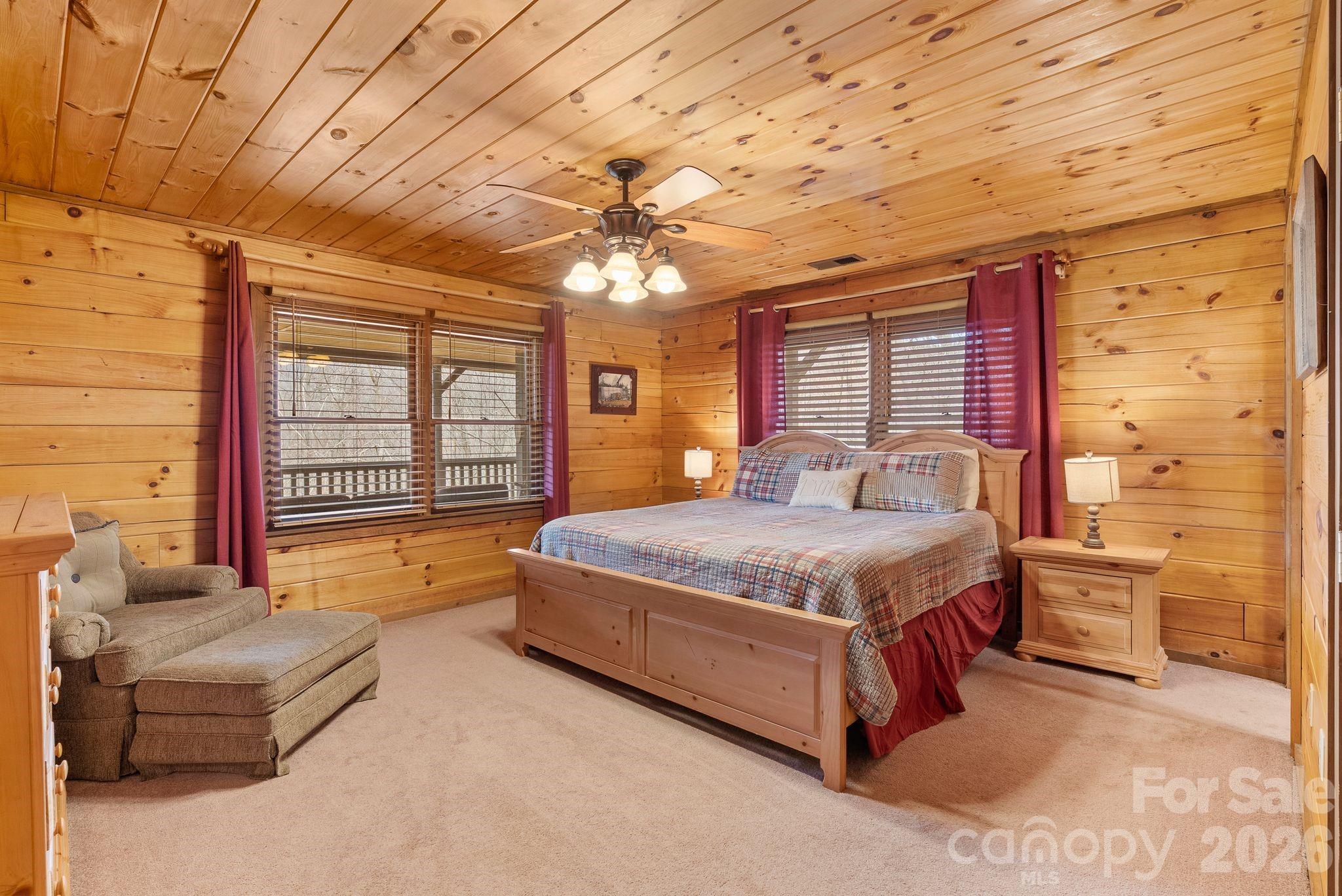 264 Moonbeam Lane Clyde, NC 28721 - Photo 17 of 46 a spacious bedroom with a bed and a chandelier