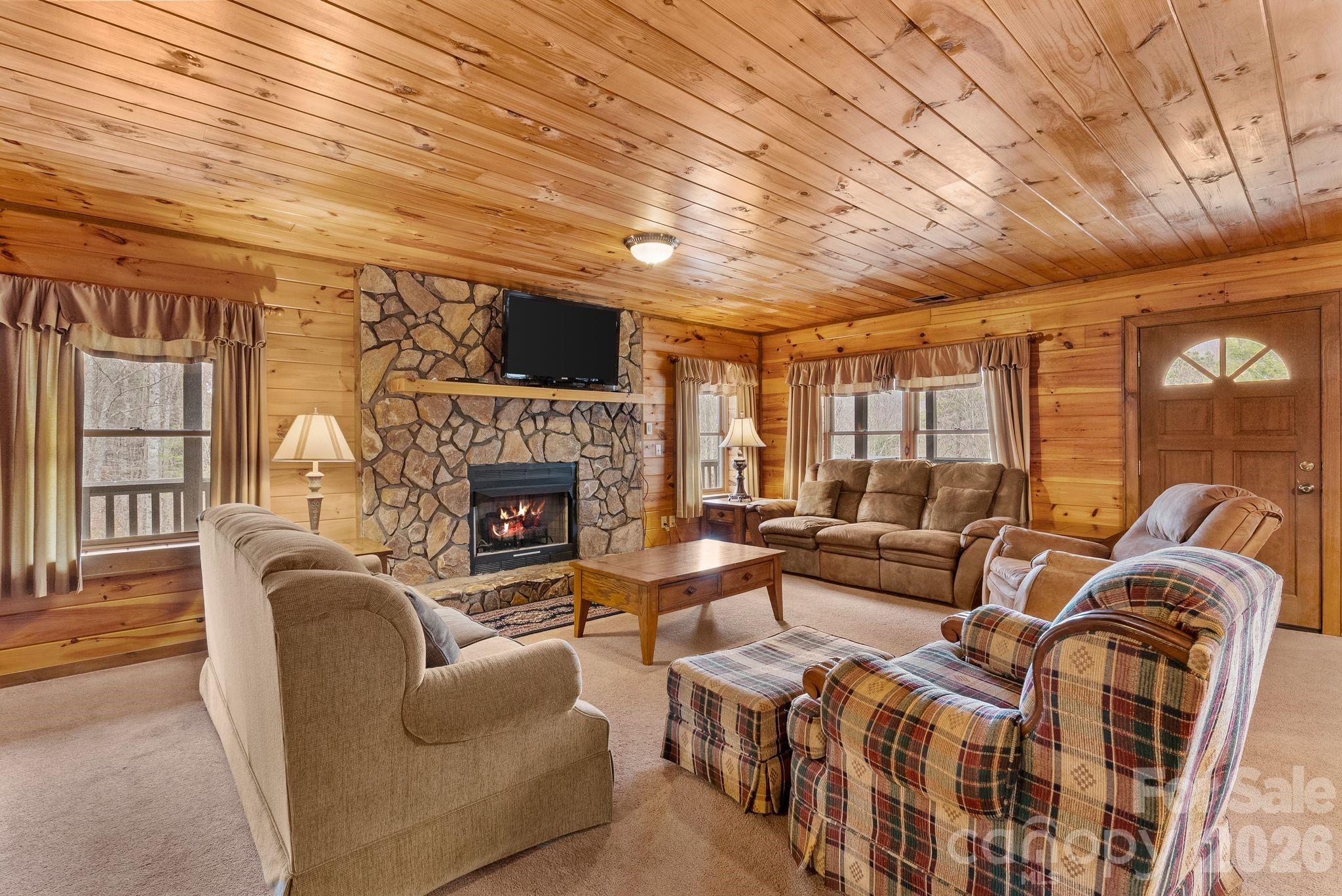 264 Moonbeam Lane Clyde, NC 28721 - Photo 23 of 46 a living room with furniture a fireplace and a flat screen tv