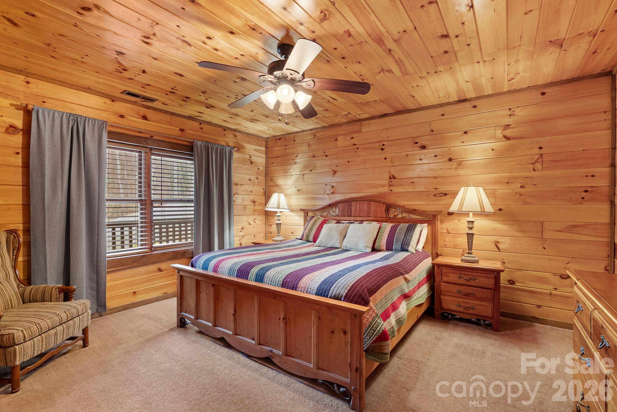 264 Moonbeam Lane Clyde, NC 28721 - Photo 28 of 46 a spacious bedroom with a bed and a chandelier