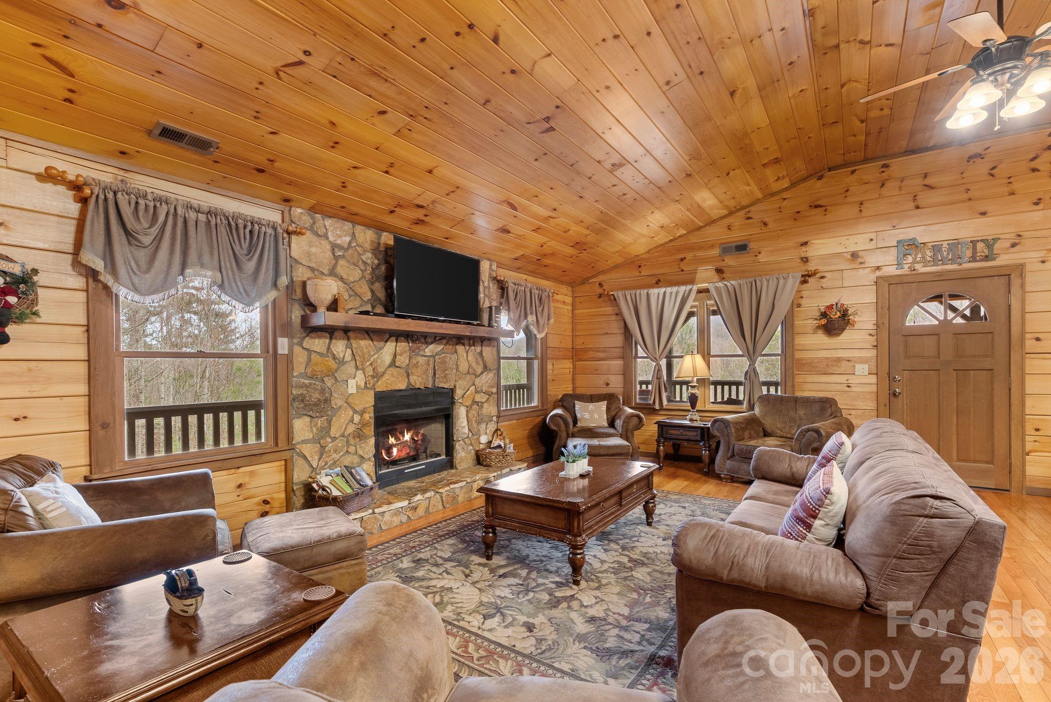 264 Moonbeam Lane Clyde, NC 28721 - Photo 6 of 46 a living room with furniture a fireplace and a flat screen tv