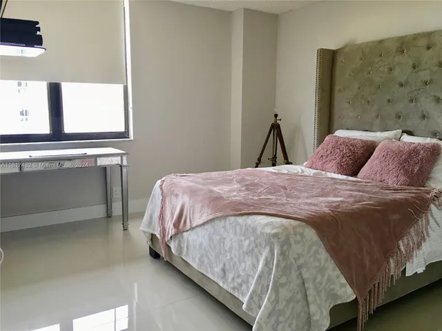 a bedroom with a bed and two windows